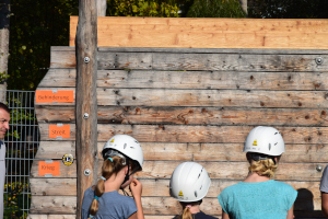 Familiengottesdienst im Niedrigseilgarten vor der Wand als Team zu überwinden